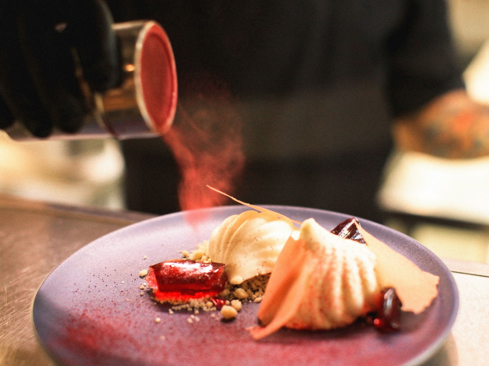 Postre terminado con polvo rojo ante el comensal